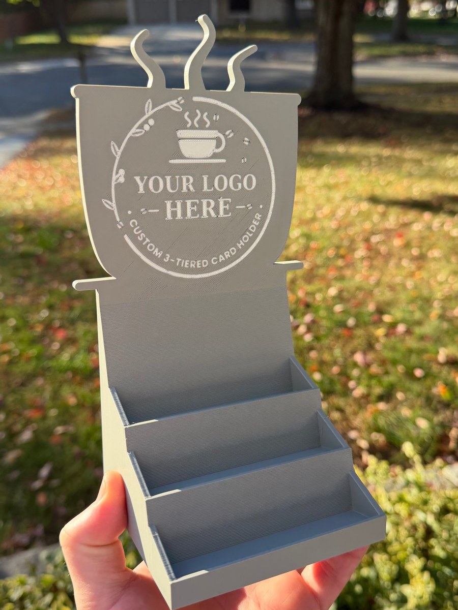 Finished grey 3-tier card holder with a coffee-cup shaped back panel and a white Your Logo Here example design